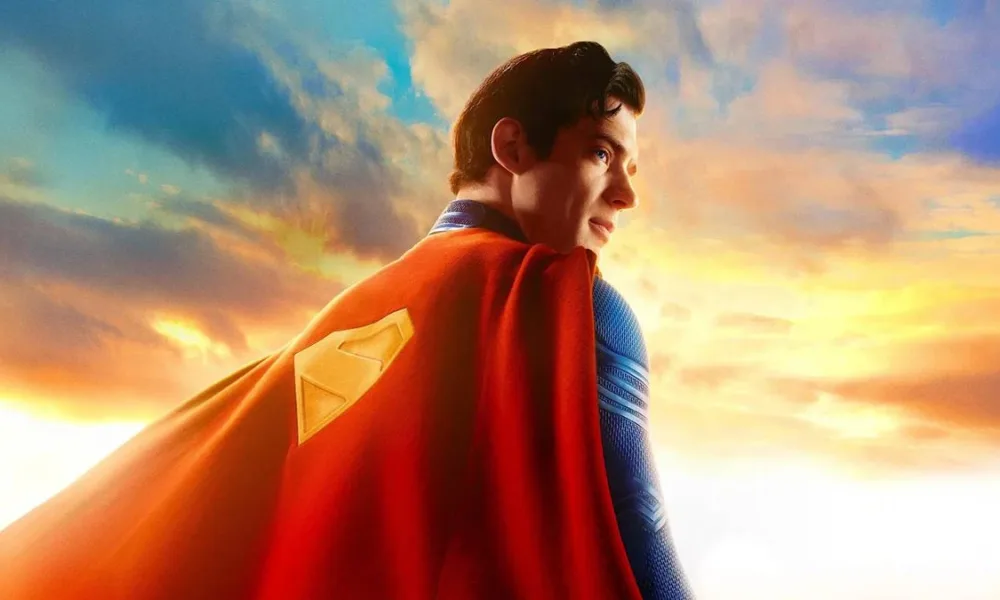 Esta imagem promocional oficial apresenta David Corenswet como o Superman, olhando para o horizonte com um traje texturizado e capa vermelha.