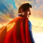 Esta imagem promocional oficial apresenta David Corenswet como o Superman, olhando para o horizonte com um traje texturizado e capa vermelha.