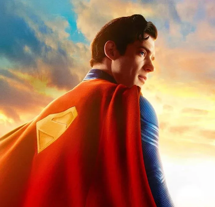 Esta imagem promocional oficial apresenta David Corenswet como o Superman, olhando para o horizonte com um traje texturizado e capa vermelha.