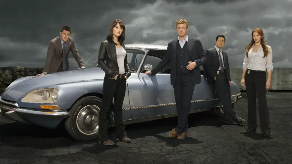 O Mentalista | 12 Curiosidades Dos Bastidores Que Você Provavelmente Não Sabia 10 O Mentalista - foto promocional da equipe da CBI na frente do carro do Patrick Jane