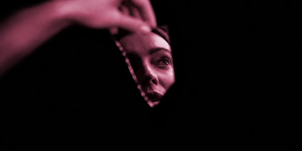 A Ex | Quando os Segredos do Passado Voltam à Tona Imagem em tons de preto e rosa mostrando parcialmente o rosto de uma mulher, visível através de uma abertura escura, enquanto uma mão aparece desfocada na parte superior. A composição cria uma atmosfera misteriosa, sombria e de suspense.