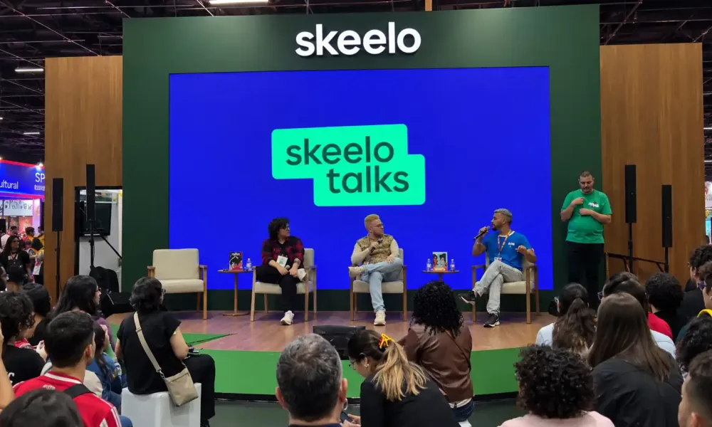 Público acompanha o painel Nordeste Ficção no Skeelo Talks da Bienal do Livro de São Paulo 2026, com Ilustralu, Pedro Rhuas e o mediador Apolo Andrade no palco.