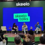 Público acompanha o painel Nordeste Ficção no Skeelo Talks da Bienal do Livro de São Paulo 2026, com Ilustralu, Pedro Rhuas e o mediador Apolo Andrade no palco.