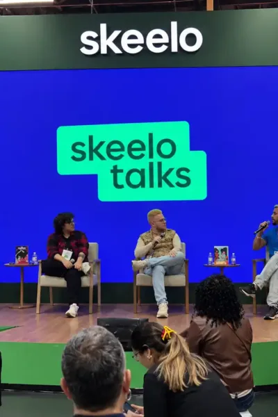 Público acompanha o painel Nordeste Ficção no Skeelo Talks da Bienal do Livro de São Paulo 2026, com Ilustralu, Pedro Rhuas e o mediador Apolo Andrade no palco.
