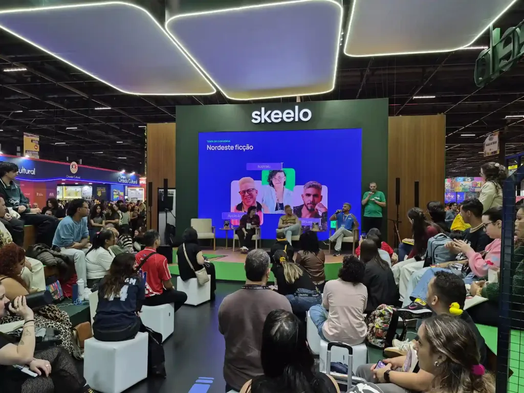 Nordeste Ficção | Novas Vozes Desafiam Estereótipos e Ampliam o Imaginário Sobre a Região na Bienal do Livro SP 2 Público acompanha o painel Nordeste Ficção no Skeelo Talks da Bienal do Livro de São Paulo 2026, com Ilustralu, Pedro Rhuas e o mediador Apolo Andrade no palco.